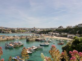 A harbor with boats and buildings in Newquay Likely Sunset