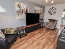 A living room with a television and seating areas at 26 Field Court