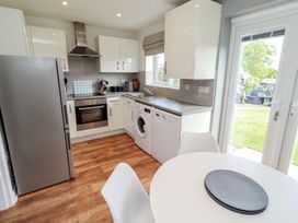 A kitchen with appliances and a dining table at 26 Field Court