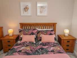 A bedroom with a bed and bedside tables at 26 Field Court