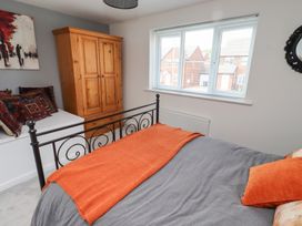 A bedroom with a bed, wardrobe and window at 26 Field Court