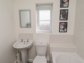 A bathroom with sink, toilet, mirror, and bathtub at 26 Field Court