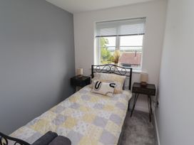 A bedroom with a bed and bedside tables at 26 Field Court