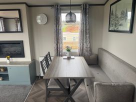 A dining area with a table and chairs at Lochwood Platinum Superior at Three Lochs Holiday Park Newton Stewart