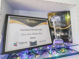 A display of an award certificate and trophy at Lochwood Platinum Superior at Three Lochs Holiday Park, Newton Stewart