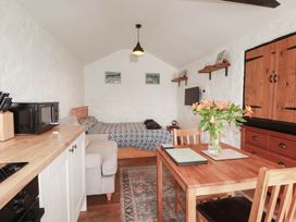 A living room with a bed and dining table at Primrose Cottage in Redruth
