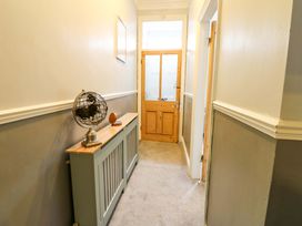 A hallway with a globe on a table and a wooden door at 17 Fairfield Road