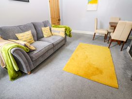 A living room with a sofa and dining table at 17 Fairfield Road