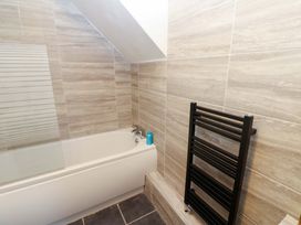 A bathroom with a bathtub and towel warmer at 17 Fairfield Road