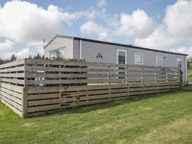 A holiday home surrounded by a wooden fence at Fanfare Superior at Three Lochs Holiday Park Newton Stewart