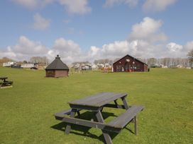 An outdoor area with a picnic table and playground at Standard Caravan at Three Lochs Holiday Park Newton Stewart