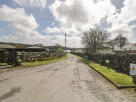 A road with stone walls and trees at Standard Caravan at Three Lochs Holiday Park in Newton Stewart