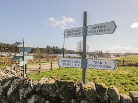 Signpost indicating directions for fishing and mountain biking at Standard Caravan at Three Lochs Holiday Park Newton Stewart
