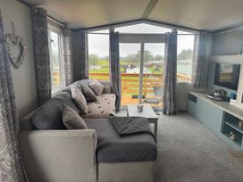 A living room with a sofa and coffee table at Lochwood Platinum Superior at Three Lochs Holiday Park Newton Stewart