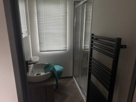 A bathroom with a wash basin and shower at Lochwood Platinum Superior at Three Lochs Holiday Park, Newton Stewart