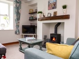 A living room with a television and fireplace at 2 Bryn Eglwys in Prenteg