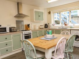 A kitchen with a table and chairs at 2 Bryn Eglwys in Prenteg