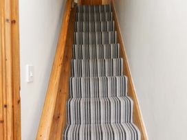 A staircase with striped carpet at 2 Bryn Eglwys in Prenteg