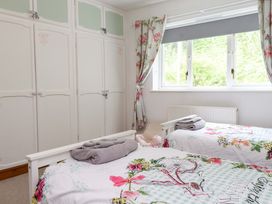 A bedroom with two beds and a wardrobe at 2 Bryn Eglwys in Prenteg