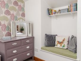 A bedroom with a mirror and a chest of drawers at 2 Bryn Eglwys in Prenteg