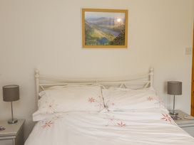 A bedroom with a bed and lamps at 2 Bryn Eglwys Prenteg
