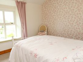 A bedroom with a bed and window at 2 Bryn Eglwys, Prenteg