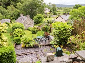 A garden with a table and chairs at 2 Bryn Eglwys in Prenteg