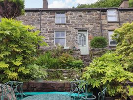A garden with plants and a stone wall at 2 Bryn Eglwys in Prenteg