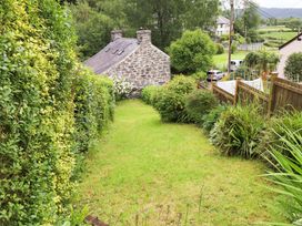 A garden with a stone house at 2 Bryn Eglwys in Prenteg