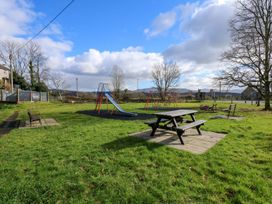 A playground with a slide and swings at 2 Bryn Eglwys, Prenteg near Porthmadog