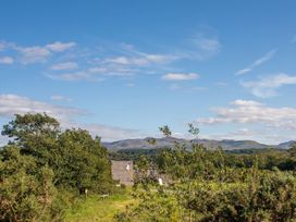 A view of a building and landscape with mountains at 2 Bryn Eglwys in Prenteg near Porthmadog