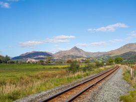 A view of railroad tracks leading to mountains in outdoor landscape at 2 Bryn Eglwys Prenteg near Porthmadog