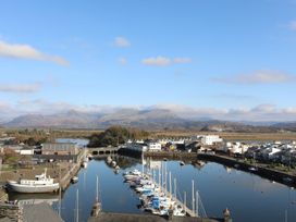 A marina with boats and mountains in the background at 2 Bryn Eglwys in Prenteg near Porthmadog