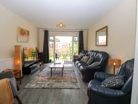 A living room with a television and sofas at The Mill House Gardens 