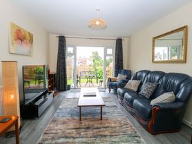 A living room with a sofa and television at The Mill House Gardens