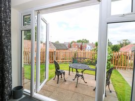 An outdoor seating area with a table and chairs at The Mill House Gardens