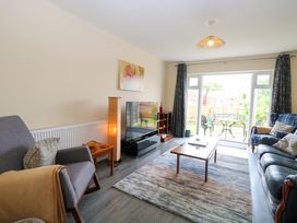 A living room with seating and a television at The Mill House Gardens