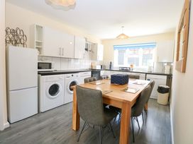 A kitchen with appliances and a dining table at The Mill House Gardens