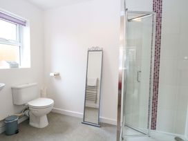 A bathroom featuring a toilet, mirror, and shower at The Mill House Gardens