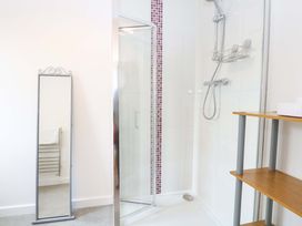 A bathroom with shower and mirror at The Mill House Gardens