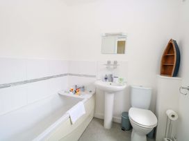 A bathroom with a bathtub, toilet, and wash basin at The Mill House Gardens