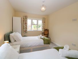 A bedroom with two beds and a wardrobe at The Mill House Gardens 