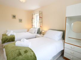 A bedroom with two beds and a dresser at The Mill House Gardens