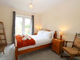 A bedroom with a bed and wardrobe at The Mill House Gardens