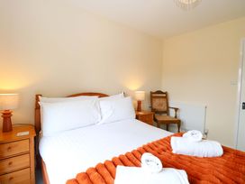 A bedroom with a bed and bedside lamps at The Mill House Gardens