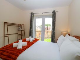 A bedroom with a bed and a sliding door at The Mill House Gardens