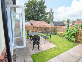 A garden with seating area and patio at The Mill House Gardens