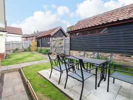 A garden with a table and chairs at The Mill House Gardens