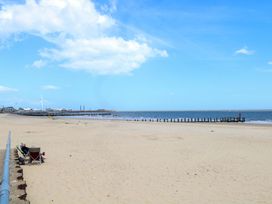 A beach with a pier and chairs at The Mill House Gardens in 