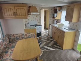 A kitchen with cabinets and appliances at Number 186 Owens Caravan Park, Abergele